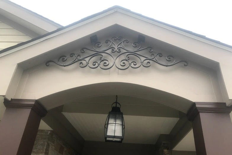 Photo of black metal decoration in an archway above a front door
