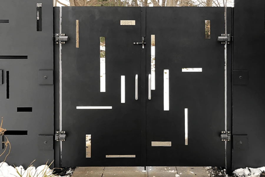 Photo of a solid black metal panel gate for a pathway with decorative slices cut into it 