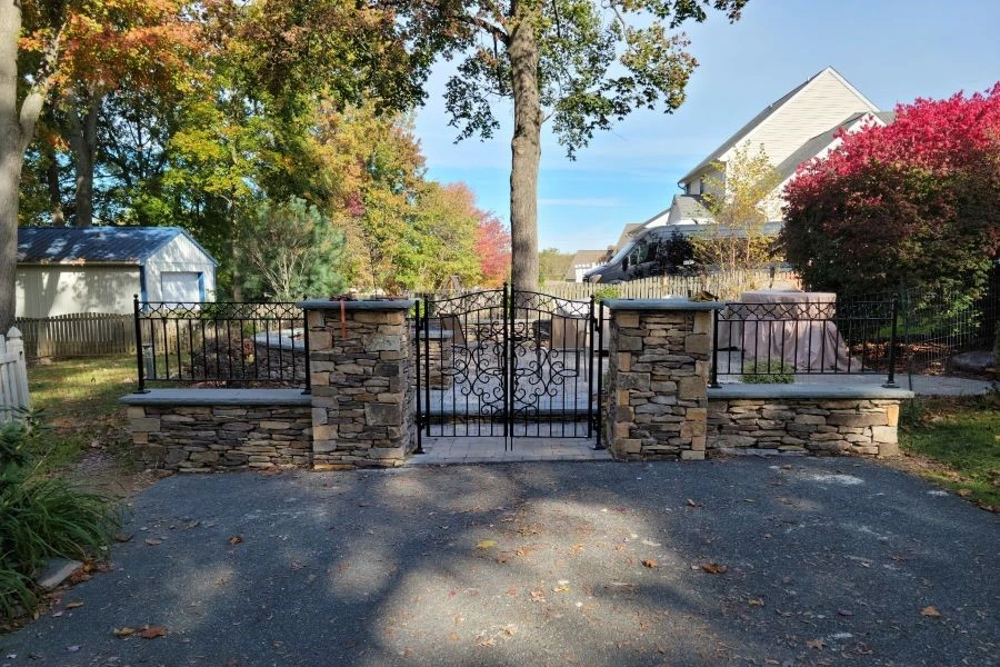 Photo of a black metal decorative gate leading to a patio 