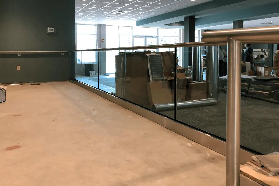 Photo of glass railing with metal bar on top