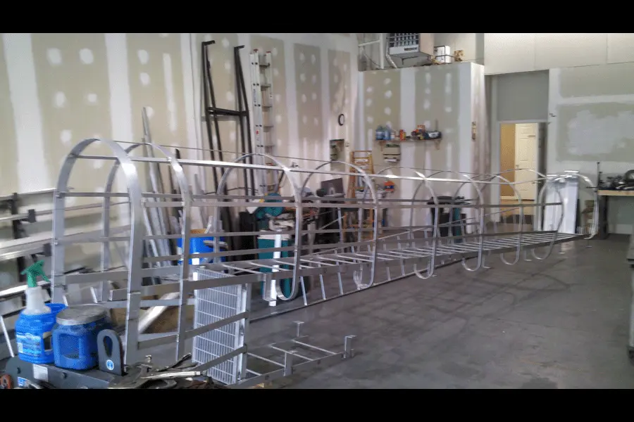 Photo of silver metal fixed ladder with safety cage in a workshop