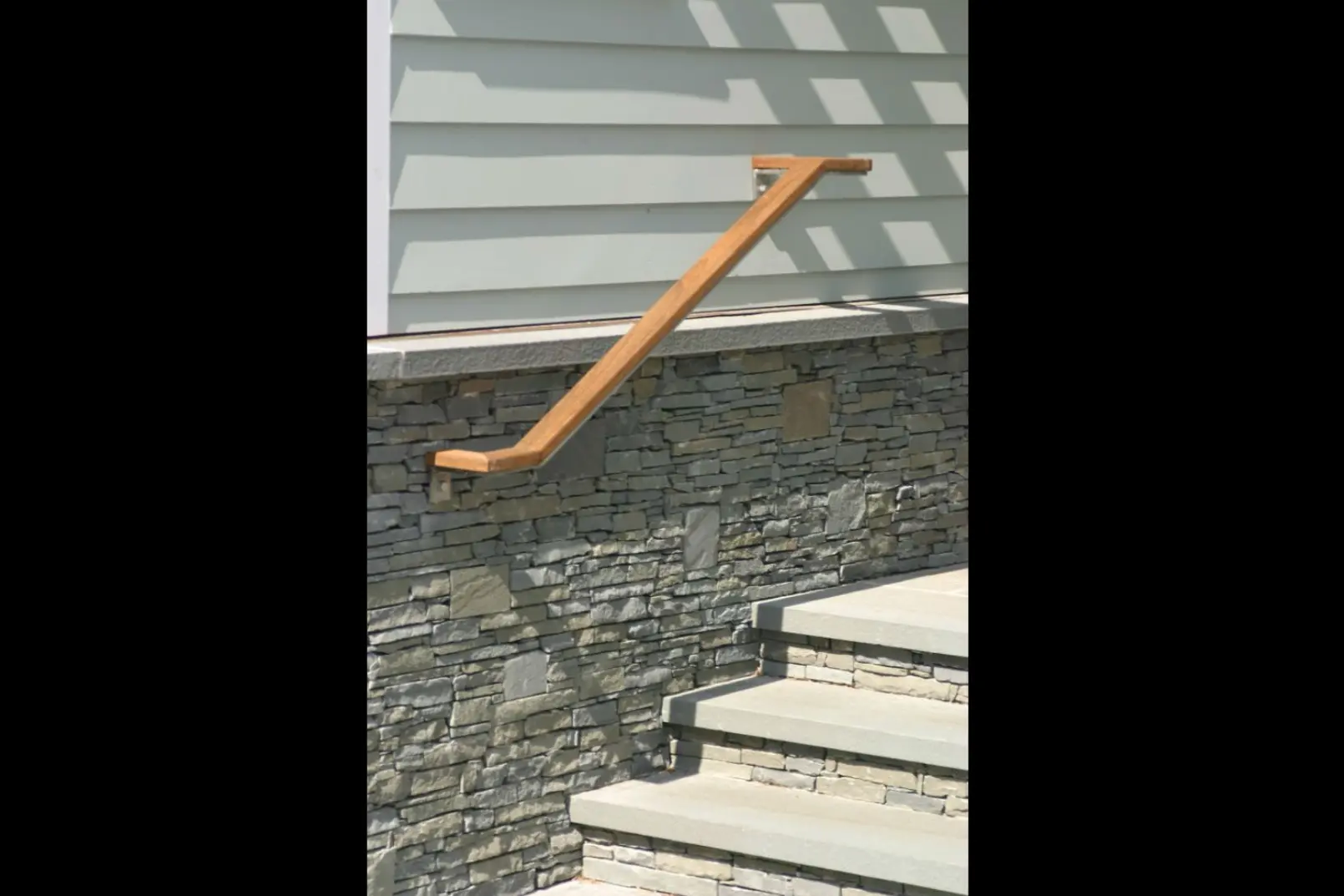Photo of grey metal railing with wooden decorative top