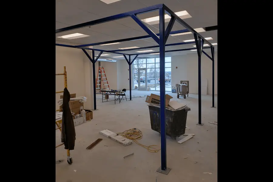 Photo of a blue metal pavilion-like structure inside a commercial building space