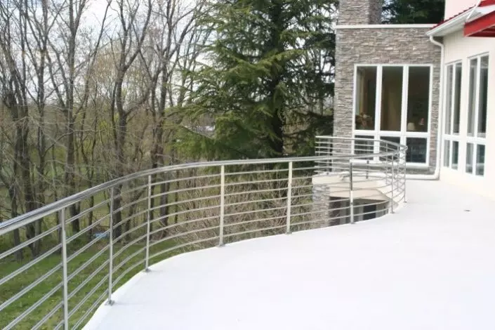 Photo of thin sleek silver metal pipe railing on a back porch
