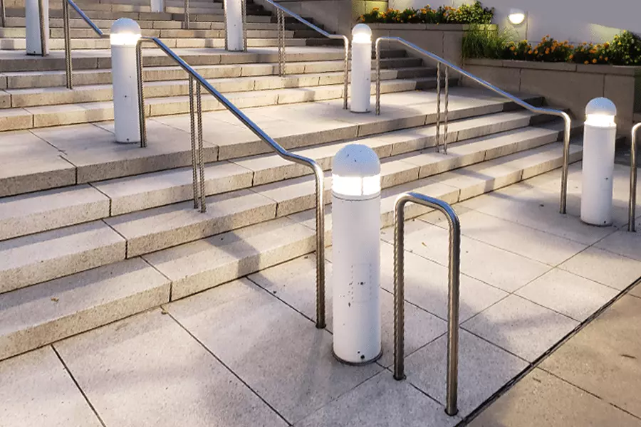 Photo of segmented silver pipe railing for an outdoor staircase at night
