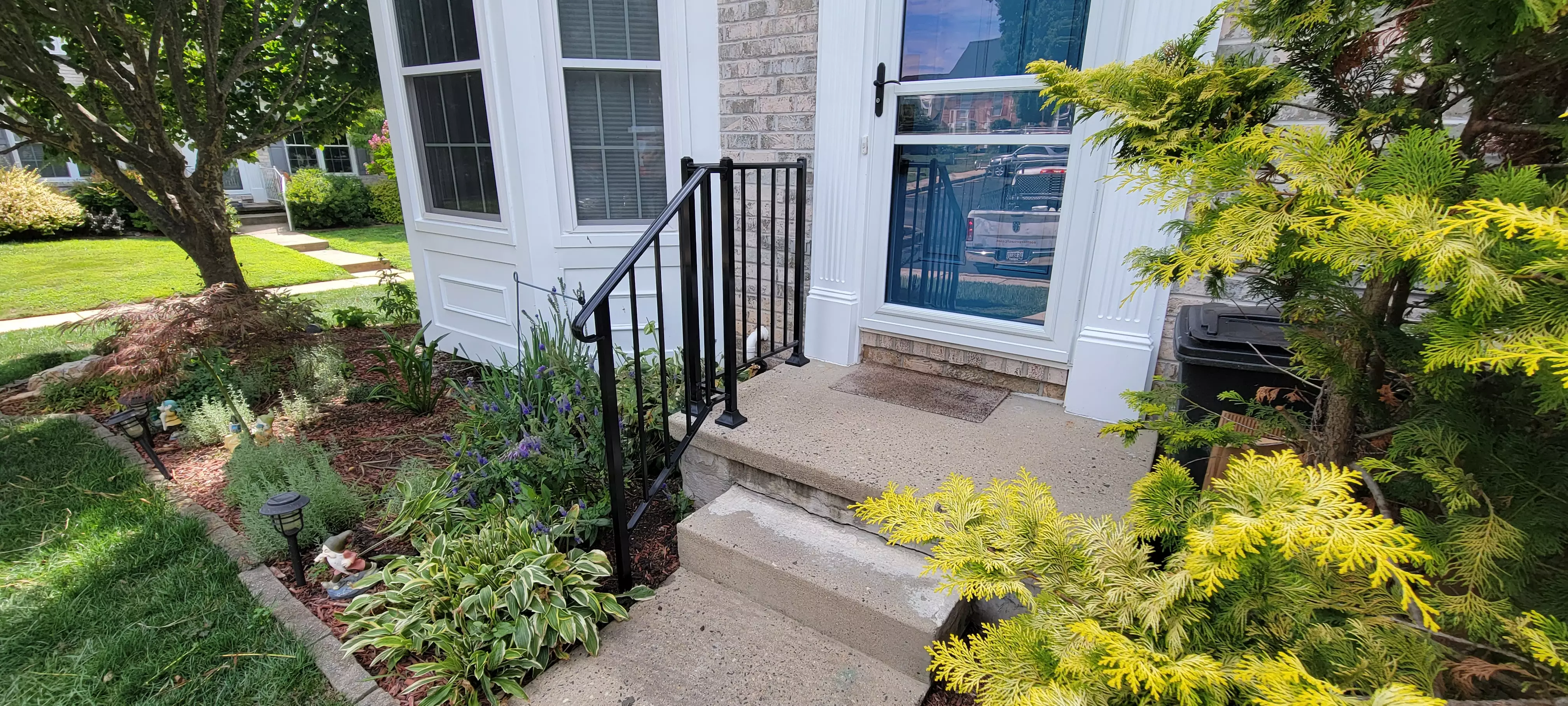 Photo of black residential railing on a step up to a house