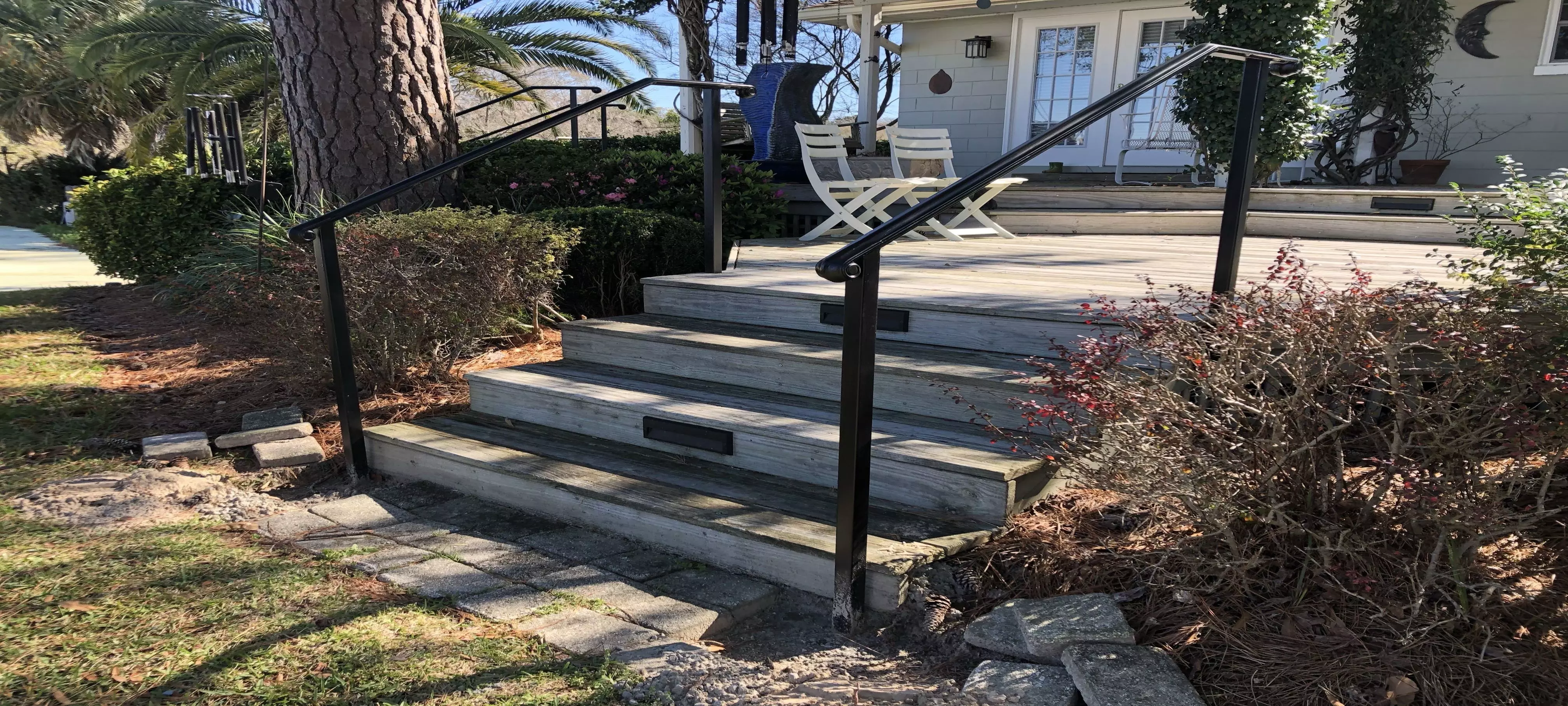 Photo of black metal residential railing for an outdoor wooden staircase