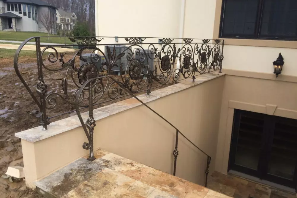 Photo of grey metal floral railing design leading to basement entrance