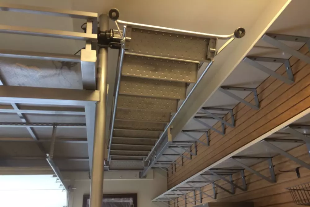 Photo of grey metal foldout staircase attached to a roof