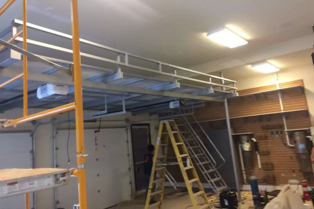 Photo of grey metal foldout staircase in folded out position in a garage